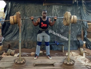 Nigerian bodybuilder Azekhumhe Omoh squatting in his homemade backyard gym