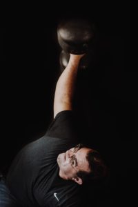 performing strongman Jeff "TRex" Bankens doing a Bent Press