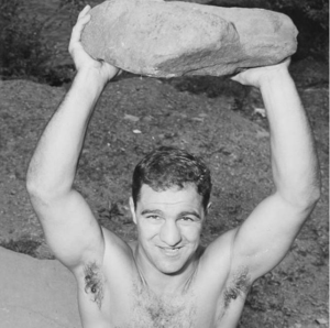 Rocky Marciano holding a stone overhead