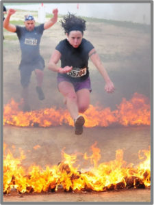 Julie Beck jumping over fire at an Obstacle Course Race