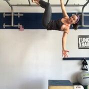 MovNat coach Julie Beck of Warrior Up Fitness doing a single arm hang