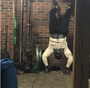 strongman competitor Brian Pankey doing handstand pushups in his backyard gym