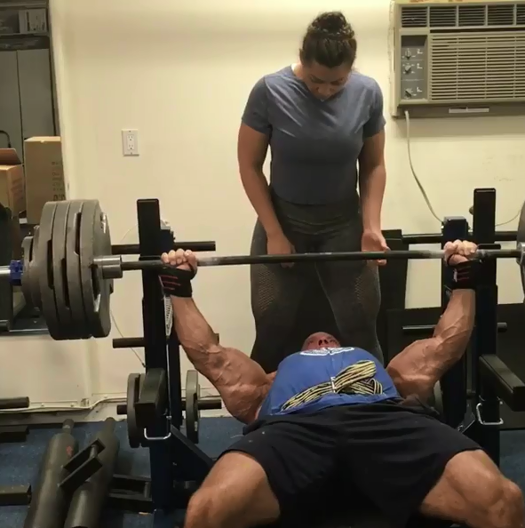 stan efferding bench pressing with his wife in his garage gym